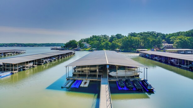 A marina with multiple docked boats and a covered area with seating.