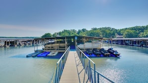A marina with a wooden dock leading to a covered boat launch area.