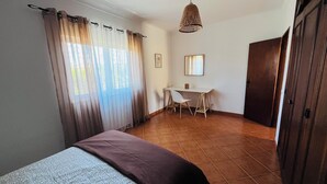 A bedroom with a bed, a desk, and a chair. - Quinta dos Moledros (Figueira)