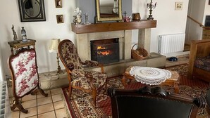 A living room with a fireplace, a mirror, and a patterned rug. - Quiet country house animals welcome minimum nights 13! (Léotoing)
