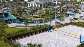 A resort with a large sandy beach area, multiple swimming pools, and palm trees. - Enchanted Clock Tower (Kissimmee)
