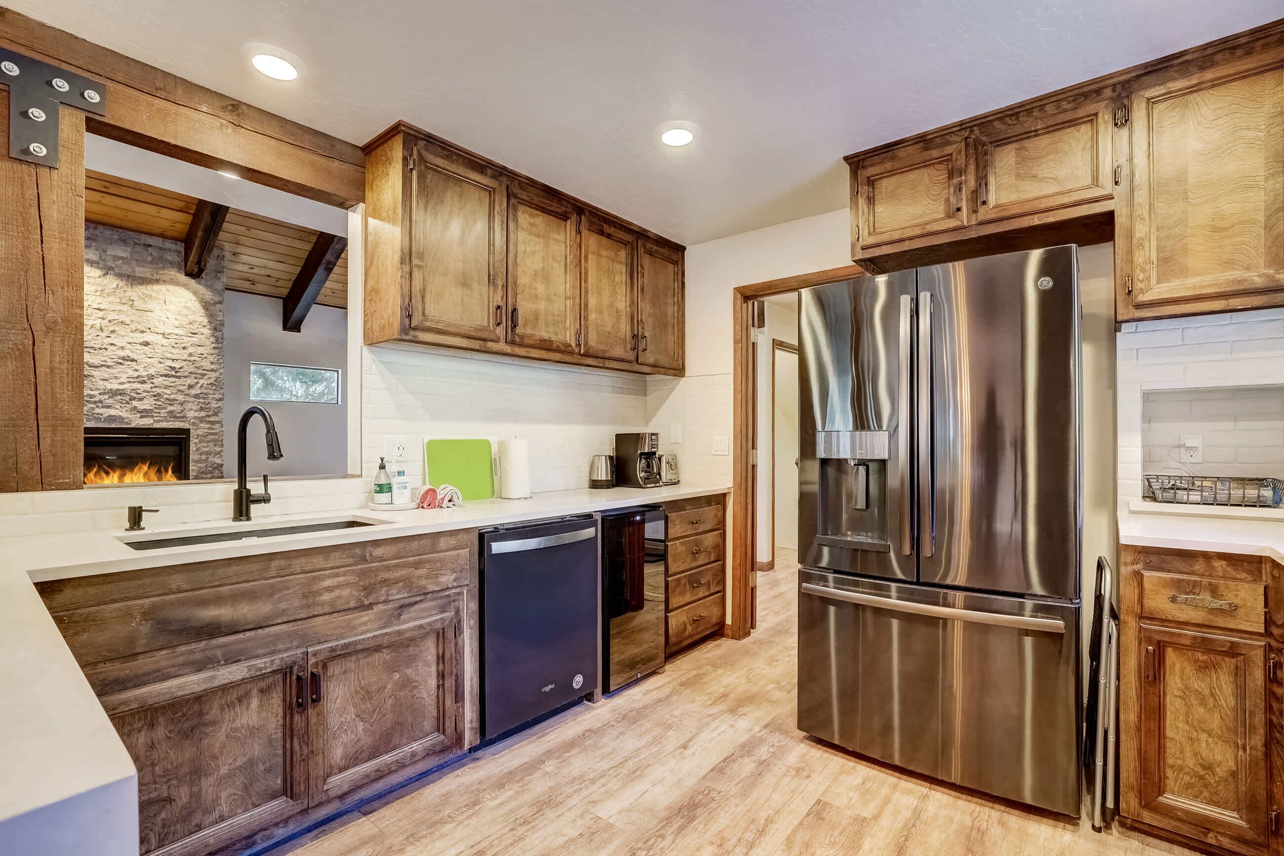 A modern kitchen with wooden cabinets, stainless steel appliances, and a built-in dishwasher.