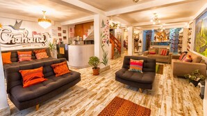 A hotel lobby with a reception desk, sofas, and a staircase. - Chakana Inn (Machu Picchu)