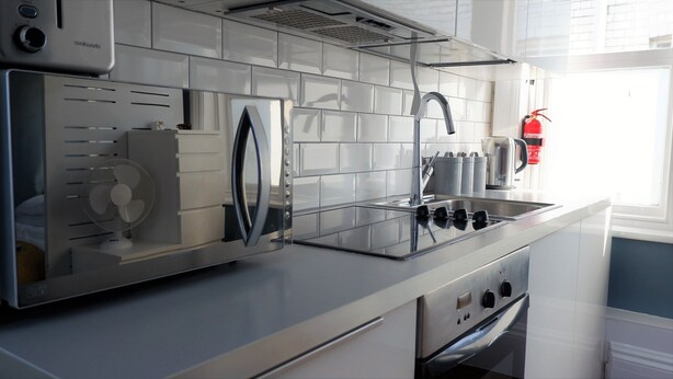 Una cocina moderna con horno empotrado, estufa y ventana que proporciona luz natural.