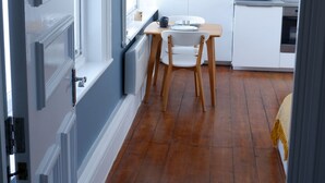 Una cocina moderna con armarios blancos, una mesa de comedor de madera y un microondas integrado.