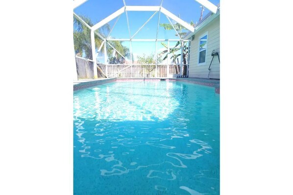 Relax by the tranquil pool surrounded by lush greenery.