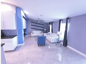 Relax in a comfortable seating area with a sofa and armchair, and enjoy the convenience of a kitchen.