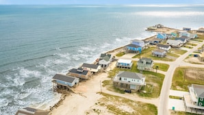 A coastal residential area with houses near the beach, featuring a mix of single and multi-story buildings, some with attached garages. - Waterfront...Breathtaking View...Great Fishing...Beautiful Home!!! (Freeport)