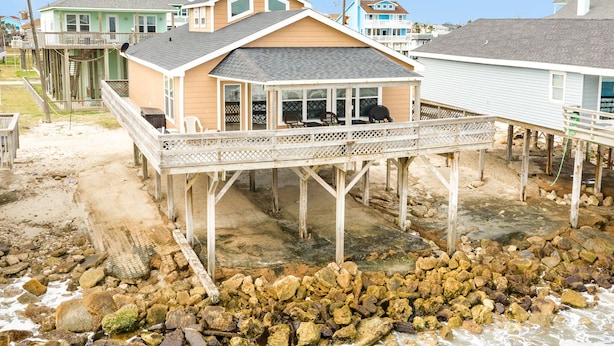 A beachfront house with a wooden deck and a covered outdoor area. - Waterfront...Breathtaking View...Great Fishing...Beautiful Home!!! (Freeport)
