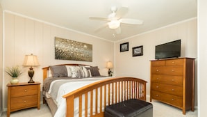 A bedroom with a wooden bed, a ceiling fan, a dresser, and a television. - Waterfront...Breathtaking View...Great Fishing...Beautiful Home!!! (Freeport)