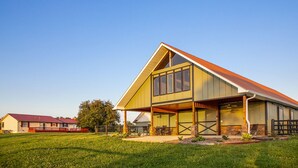 A modern two-story house with a large front porch, a garage, and a well-maintained lawn.