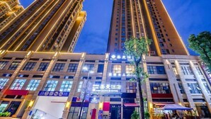 A high-rise hotel with multiple floors, illuminated windows, and a prominent sign for the Saint Hotel. - Saint Hotel (Chongqing)