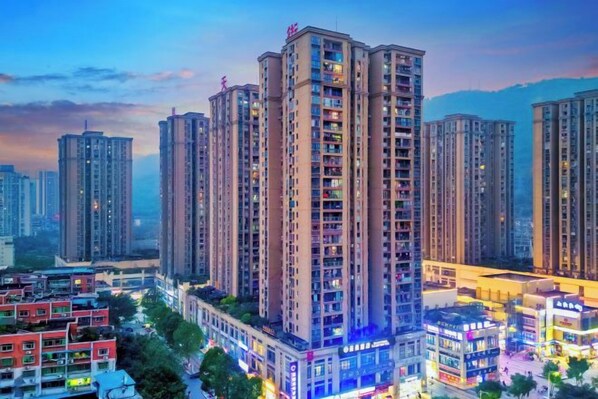 A high-rise residential building with multiple floors, surrounded by other high-rise buildings, and a busy street with commercial establishments. - Saint Hotel (Chongqing)