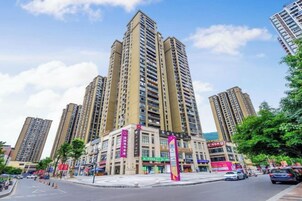 Un edificio de gran altura con varios pisos, un paso de peatones y cielo despejado.