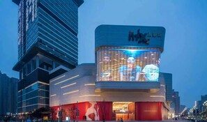 Un edificio moderno con una fachada de vidrio llamativa y señalización iluminada.