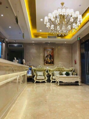 A lobby with a grand chandelier, a reception desk, and a classic sofa set. - Vienna Hotel (Chongqing)