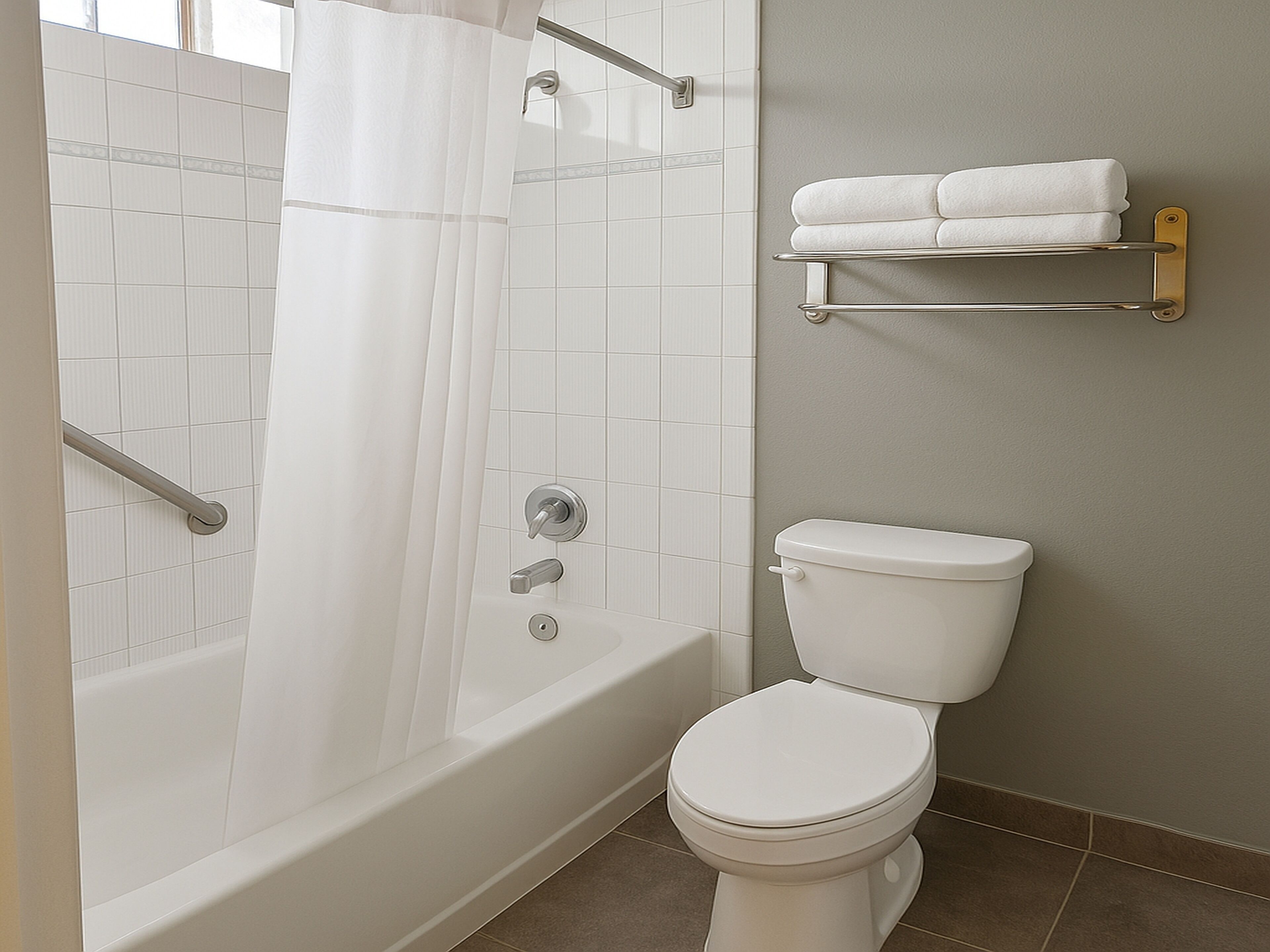 Un baño con bañera, inodoro y cortina de ducha.
