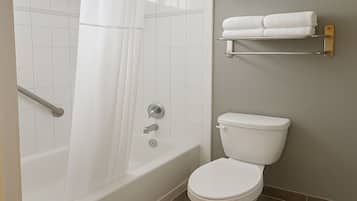 Un baño con bañera, inodoro y cortina de ducha.