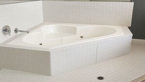Une salle de bain moderne avec une baignoire sur pieds, des murs carrelés et un plancher en bois.