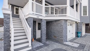 A two-story house with a white exterior, a stone facade, and a balcony with white railings. - Stunning Point Pleasant Beach 6BR 5Bath Ocean Front Home - Heated Inground Pool (Point Pleasant Beach)