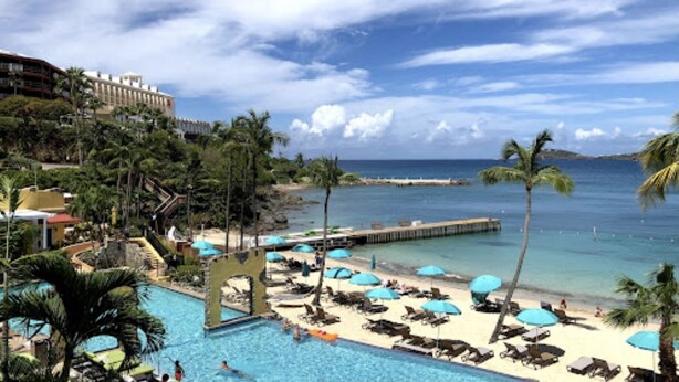 Un resort con piscina, playa y vista al océano.