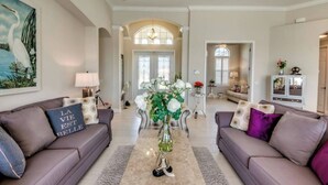 A spacious living room with two sofas, a coffee table, and a large window. - Villa Blissful Bay - The Entry To Paradise (Cape Coral)