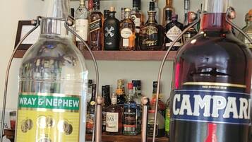 Duas garrafas de rum em um balcão de bar, com uma placa de 'Welcome' acima.
