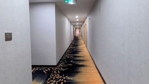 A long, narrow hotel corridor with a patterned carpet and a ceiling-mounted projector. - Zhijin Shancheng Hotel (Zhijin)