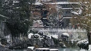 A traditional Chinese garden with a pond, rock formations, and a pavilion. - Zhijin Shancheng Hotel (Zhijin)