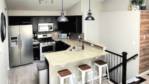 A modern kitchen with a central island, stainless steel appliances, and pendant lighting. - $0Fees-6bed/6bath-Easy Red Rocks/Downtown/OldeTown (Arvada)