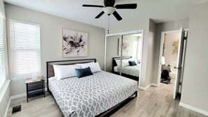 A bedroom with a bed, a ceiling fan, a window, and a mirror. - $0Fees-6bed/6bath-Easy Red Rocks/Downtown/OldeTown (Arvada)