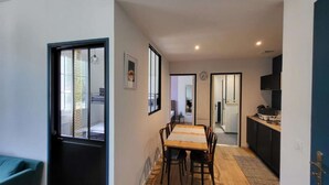Een moderne keuken met een eethoek, een zichtbare klok en uitzicht op een andere kamer.