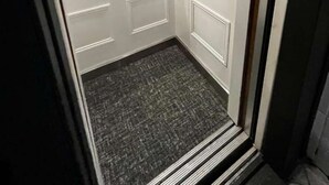Un ascenseur compact avec un mur décoré et un petit miroir.