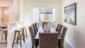 A dining area with a long table, six chairs, and two decorative vases. - Modern clean relaxing gateway! Close to all LA fun! (Monterey Park)