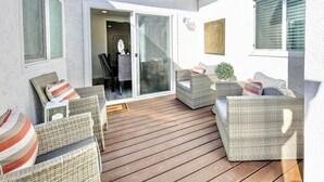 An outdoor patio with wicker furniture and a sliding glass door leading to an interior space. - Modern clean relaxing gateway! Close to all LA fun! (Monterey Park)