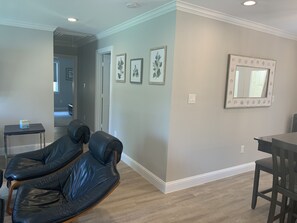 Experience a warm and inviting atmosphere in this contemporary living space with a light blue accent wall and a dining area.