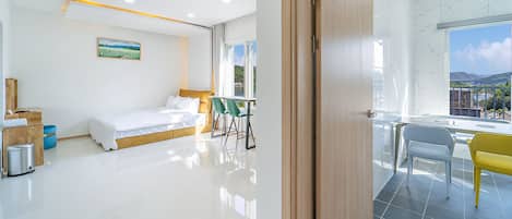 Habitación de hotel moderna con cama, escritorio y vistas al exterior.
