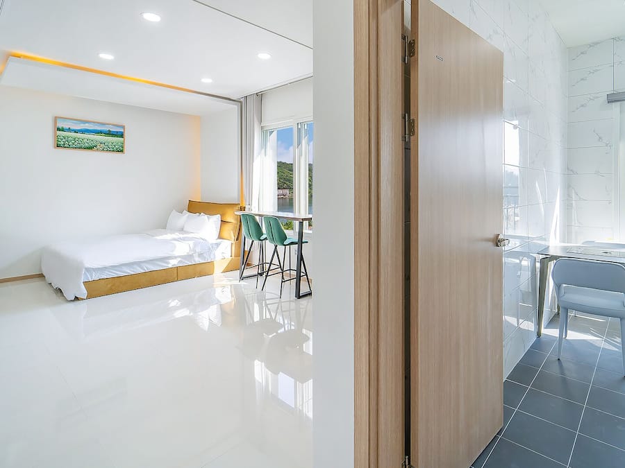 Quarto de hotel moderno com cama, escrivaninha e vista para o exterior.