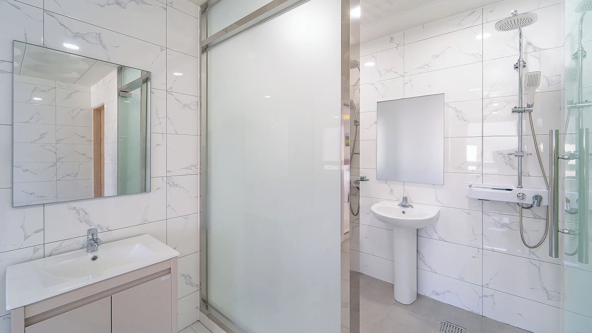 Un baño moderno con cabina de ducha de vidrio, un lavamanos y un espejo.