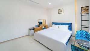 Een hotelkamer met een bed, een bureau, een stoel en een kledingkast.