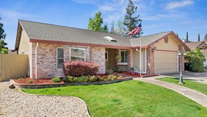 A two-story house with a brick facade, a garage, and a well-maintained lawn. - Gorgeous House with POOL!! (Elk Grove)