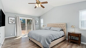 A bedroom with a bed, a ceiling fan, a nightstand, and a window. - Gorgeous House with POOL!! (Elk Grove)