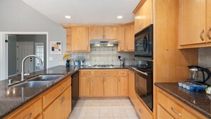 A kitchen with wooden cabinets, stainless steel appliances, and a granite countertop. - Gorgeous House with POOL!! (Elk Grove)