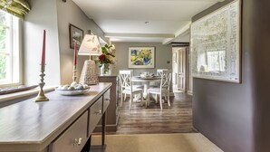 Un coin repas comprenant une table et des chaises, une lampe et un vase avec des fleurs.