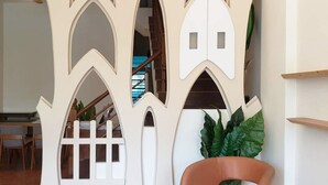 A modern interior with a unique tree-shaped partition, a staircase, and a seating area with a plant. - Moon Deer (Taitung)