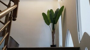 A staircase with wooden handrails and a potted plant on the landing. - Moon Deer (Taitung)
