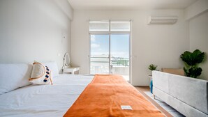 A hotel room with a bed, a sofa, a large window, and a balcony. - Moon Deer (Taitung)