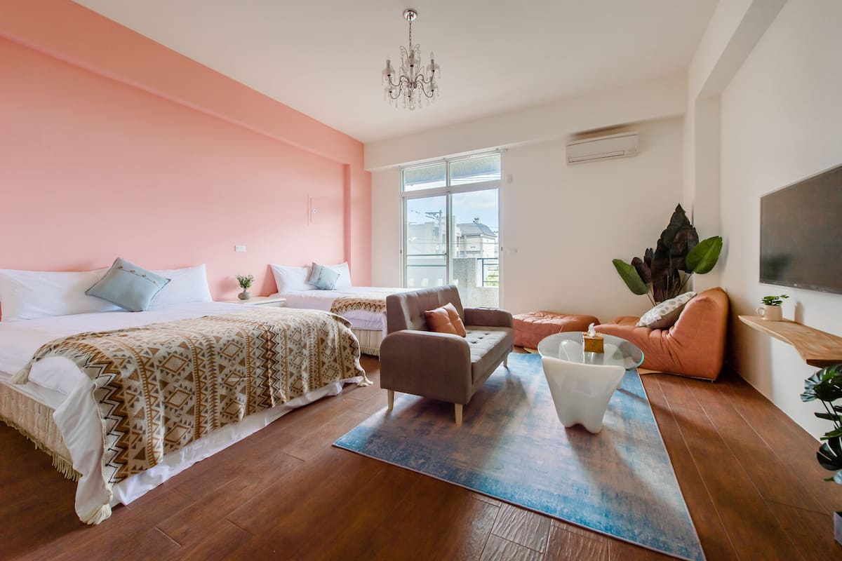 Un dormitorio moderno con una cama grande, un sofá, una mesa de centro y un televisor.