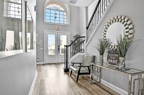 Stunning lobby with a grand staircase, elegant console table, and large windows.