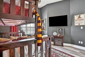 Cozy retreat with a bunk bed on the upper level, flat-screen TV, and a decorative table below.